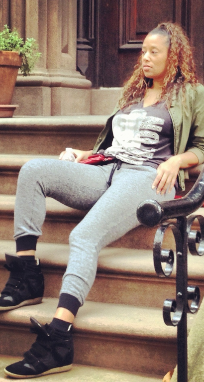 Sajuan Celestin seated on the steps of a Brooklyn brownstone